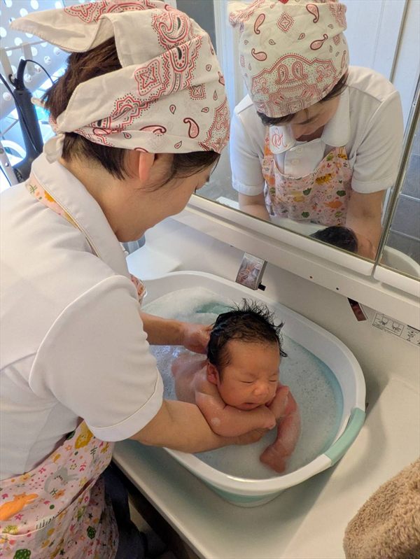 赤ちゃんの沐浴をサポートしながらお話を伺う様子